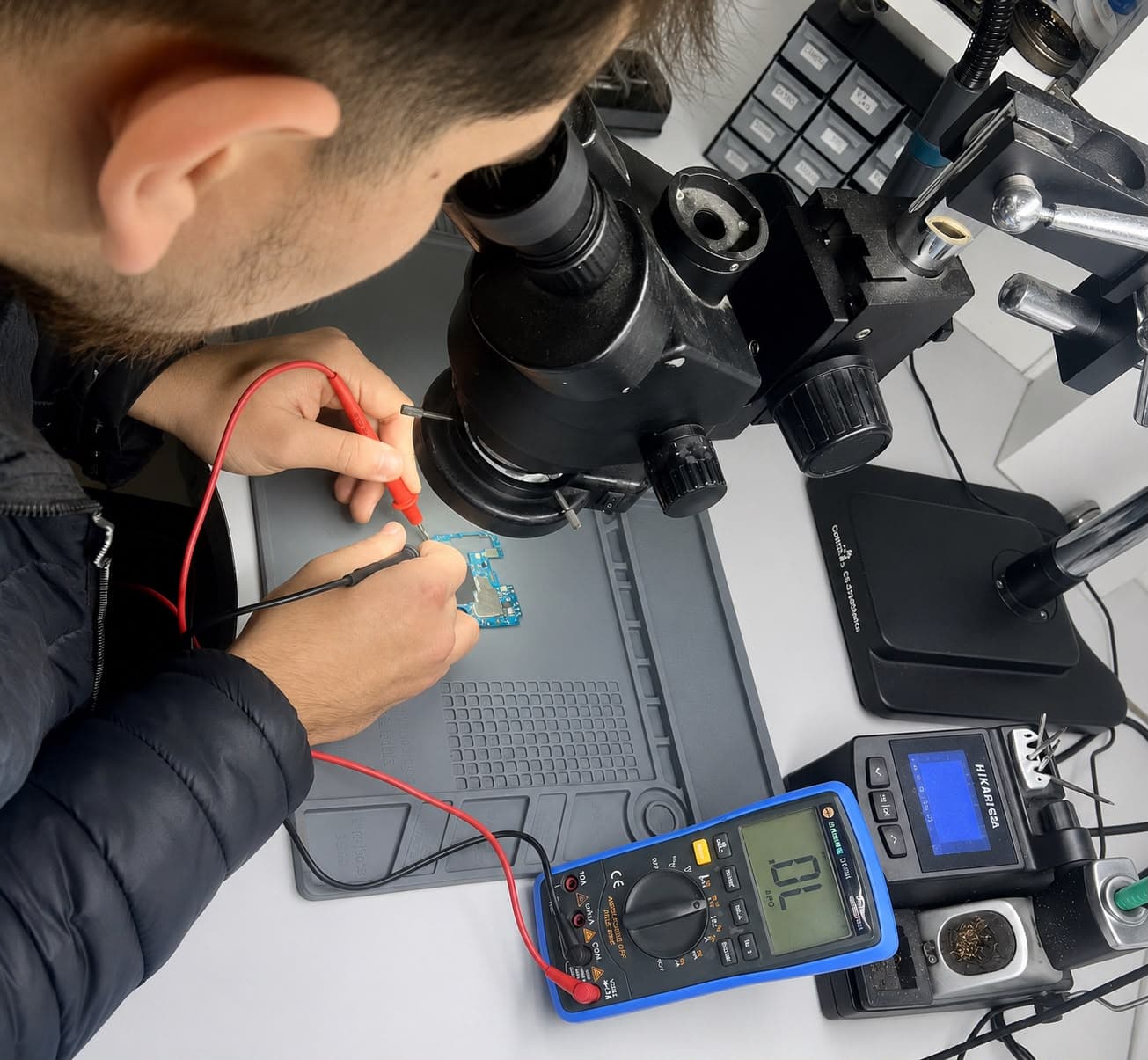 Técnico da SOS Celulares analisando uma placa no microscópio
