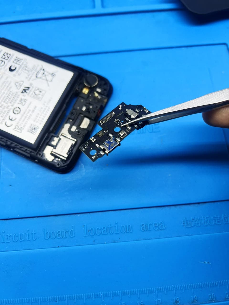 Troca de conector de carga em bancada da SOS Celulares
